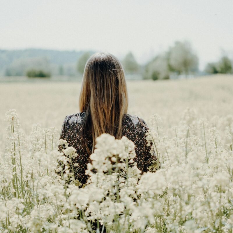 woman standing on white flower field